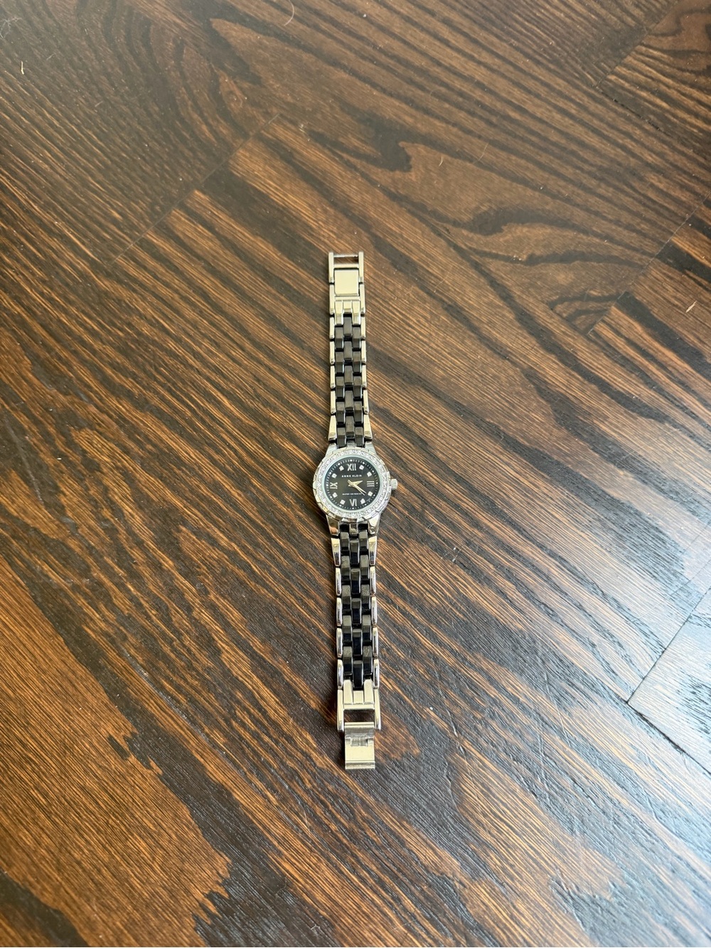 Anne Klein silver-tone bracelet watch with a black face  and rhinestone bezel